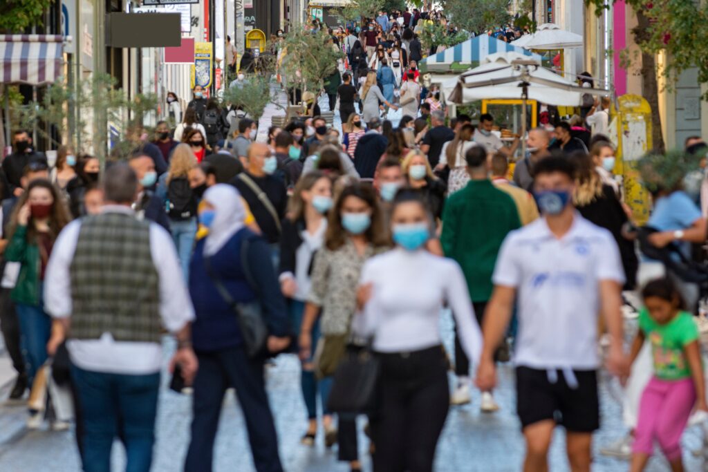 Busy city sidewalk with everyone wearing surgical masks.